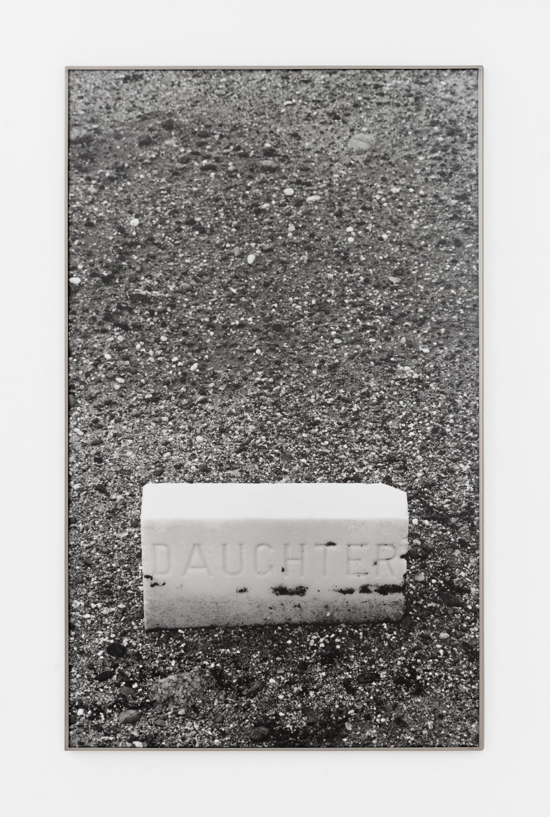 Fotografia in bianco e nero di una lapide con la scritta Daughter